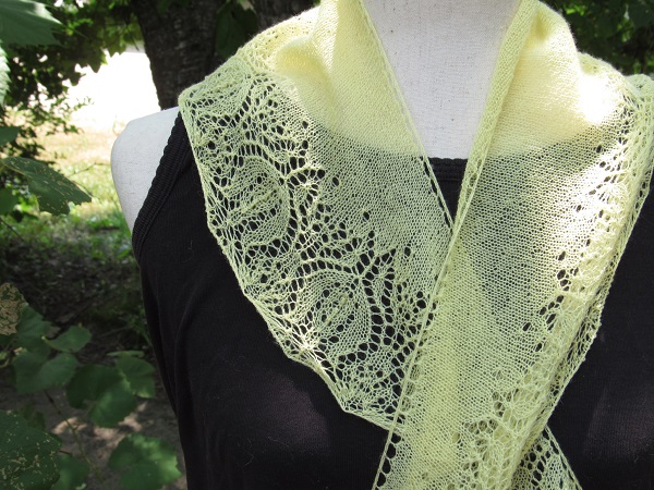 a light yellow scarf with a tulip like pattern draped over a dress form